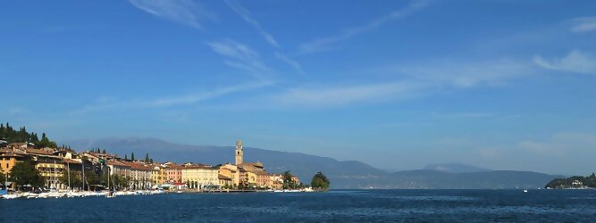 Trip Tschechien beliebte Urlaubsziele am Gardasee -  Mit einer Fläche von 370 km² ist der Gardasee der größte See Italiens. Es liegt am Fuße der Alpen und erstreckt sich über drei Staaten: Lombardei, Venetien und Trentino. Die maximale Tiefe des Sees beträgt 346 m, er hat eine längliche Form und sein nördliches Ende ist sehr schmal. Dort ist der See von den Bergen der Gruppo di Baldo umgeben. Du trittst aus deinem gemütlichen Hotelzimmer und es begrüßt dich die warme italienische Sonne. Du blickst auf den atemberaubenden Gardasee, der in zahlreichen Blautönen schimmert - von tiefem Dunkelblau bis zu funkelndem Türkis. Majestätische Berge umgeben dich, während die Brise sanft deine Haut streichelt und der Duft von blühenden Zitronenbäumen deine Nase kitzelt. Du schlenderst die malerischen, engen Gassen entlang, vorbei an farbenfrohen, blumengeschmückten Häusern. Vereinzelt unterbricht das fröhliche Lachen der Einheimischen die friedvolle Stille. Du fühlst dich wie in einem Traum, der nicht enden will. Jeder Schritt führt dich zu neuen Entdeckungen und Abenteuern. Du probierst die köstliche italienische Küche mit ihren frischen Zutaten und verführerischen Aromen. Die Sonne geht langsam unter und taucht den Himmel in ein leuchtendes Orange-rot - ein spektakulärer Anblick.